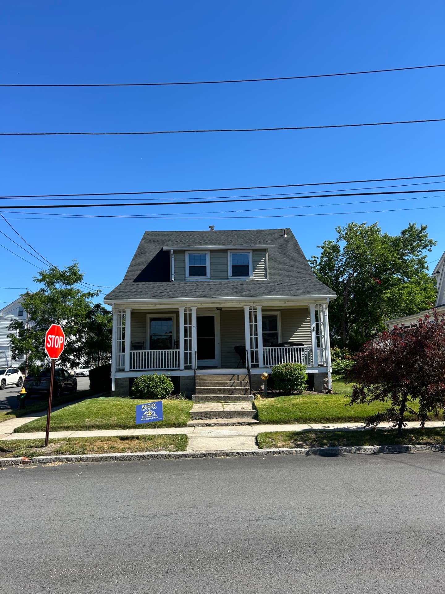 Completed shingle roof replacement on a Rhode Island cape-style home with front porch