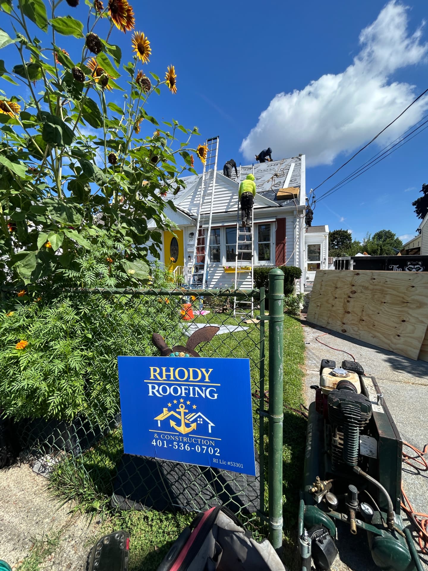 Rhody Roofing yard sign in front of a home during a roof replacement project